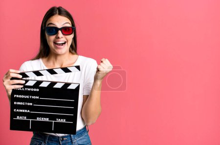 Photo for Young pretty woman feeling shocked,laughing and celebrating success. cinema film or movie concept - Royalty Free Image