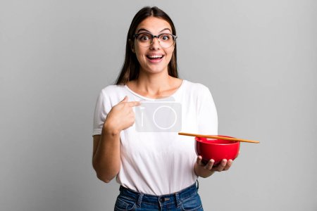 Téléchargez les photos : Jeune jolie femme se sentant heureux et pointant vers soi-même avec un excité. concept de nouilles ramen japonaises - en image libre de droit