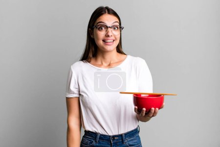 Photo for Young pretty woman looking happy and pleasantly surprised. japanese ramen noodles concept - Royalty Free Image