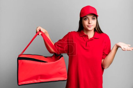 Photo for Young pretty woman feeling puzzled and confused and doubting. pizza delivery concept - Royalty Free Image