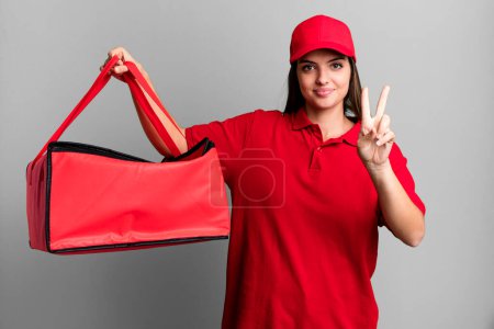 Photo for Young pretty woman smiling and looking friendly, showing number two. pizza delivery concept - Royalty Free Image