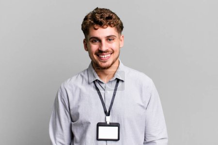 jeune homme caucasien adulte souriant heureux avec une main sur la hanche et confiant. carte d'accréditation vierge ID concept