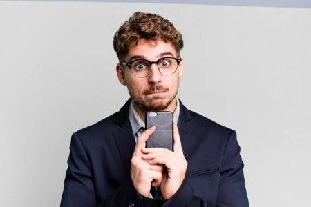 Téléchargez les photos : Young adult caucasian businessman with a smartphone - en image libre de droit