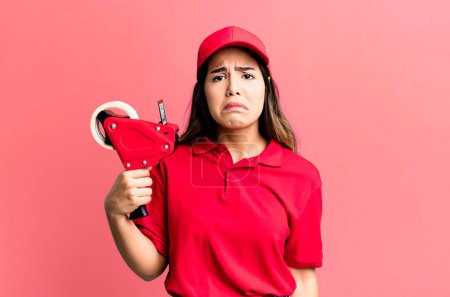 Photo for Hispanic pretty woman feeling sad and whiney with an unhappy look and crying. packer and delivery employee - Royalty Free Image