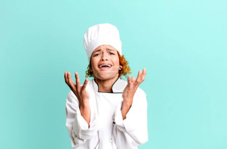 Photo for Red hair pretty woman looking desperate, frustrated and stressed. chef concept - Royalty Free Image