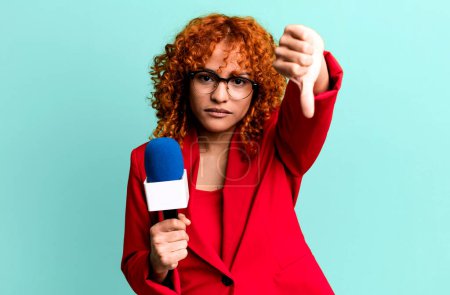 Photo for Red hair pretty woman feeling cross,showing thumbs down. journalist and presenter concept - Royalty Free Image