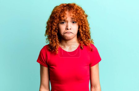 Photo for Redhair pretty woman feeling sad and stressed, upset because of a bad surprise, with a negative, anxious look - Royalty Free Image