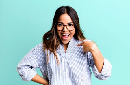 Photo for Hispanic pretty woman looking happy, proud and surprised, cheerfully pointing to self, feeling confident and lofty - Royalty Free Image