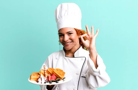 Photo for Red hair pretty chef woman cooking waffles - Royalty Free Image