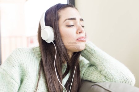 Foto de Bonita mujer joven escuchar música con auriculares. casa de diseño de interiores - Imagen libre de derechos