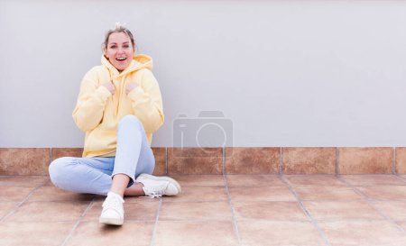 Photo for Pretty caucasian sitting  woman feeling happy, surprised and proud, pointing to self with an excited, amazed look - Royalty Free Image