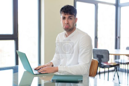 Photo for Young handsome man feeling sad and whiney with an unhappy look and crying. working at home concept - Royalty Free Image