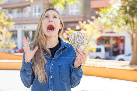 Photo for Woman screaming with hands up in the air. dollar banknotes concept - Royalty Free Image