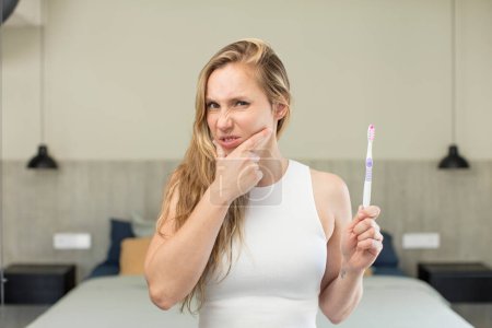 Photo for With mouth and eyes wide open and hand on chin. toothbrush concept - Royalty Free Image