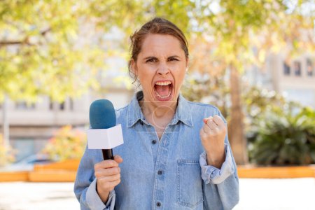 Foto de Joven bonita mujer mirando enojado, molesto y frustrado. presentador y concepto de micrófono - Imagen libre de derechos
