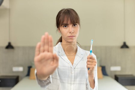 Photo for Young pretty woman looking serious showing open palm making stop gesture. mouthwash concept - Royalty Free Image