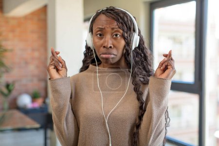 Foto de Mujer afro negro cruzando los dedos y esperando buena suerte. escuchar música concepto - Imagen libre de derechos