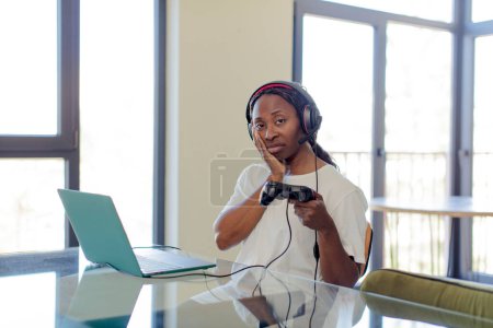 Téléchargez les photos : Noir afro femme se sentir ennuyé, frustré et somnolent après un fatigant. concept de joueur - en image libre de droit