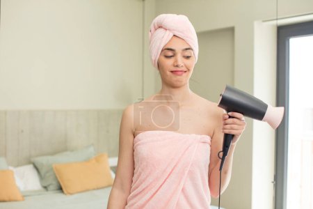 Photo for Pretty young model smiling and looking with a happy confident expression. hair dryer concept - Royalty Free Image