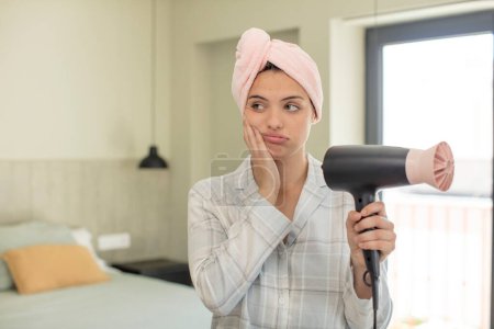 Photo for Young pretty woman feeling bored, frustrated and sleepy after a tiresome. hair dryer concept - Royalty Free Image