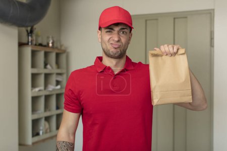 Photo for Young handsome man feeling sad and whiney with an unhappy look and crying. delivery man concept - Royalty Free Image