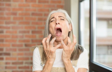 Téléchargez les photos : Senior jolie femme regardant désespérée et frustrée, stressée, malheureuse et agacée, criant et criant - en image libre de droit
