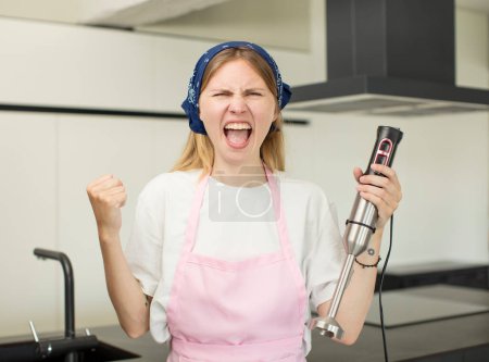 Photo for Young pretty woman looking angry, annoyed and frustrated. chef and hand blender concept - Royalty Free Image