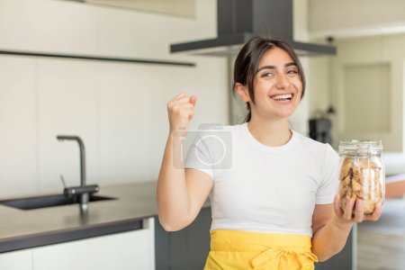 Photo for Young woman feeling shocked,laughing and celebrating success. cookies concept - Royalty Free Image