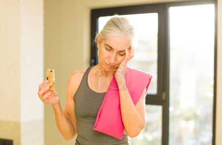 Téléchargez les photos : Senior jolie femme se sentant ennuyé, frustré et somnolent après un fatigant. concept de fitness - en image libre de droit