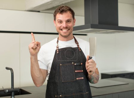 Photo for Smiling cheerfully, feeling happy and pointing to the side. chef at home - Royalty Free Image