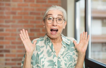 Téléchargez les photos : Senior jolie femme se sentant heureuse, excitée, surprise ou choquée, souriante et étonnée de quelque chose d'incroyable - en image libre de droit