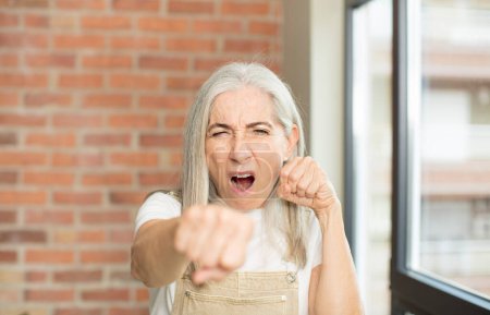 Photo for Senior pretty woman looking confident, angry, strong and aggressive, with fists ready to fight in boxing position - Royalty Free Image