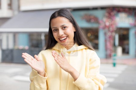 Foto de Mujer hispana bonita sintiéndose feliz y exitosa, sonriendo y aplaudiendo, diciendo felicitaciones con un aplauso - Imagen libre de derechos