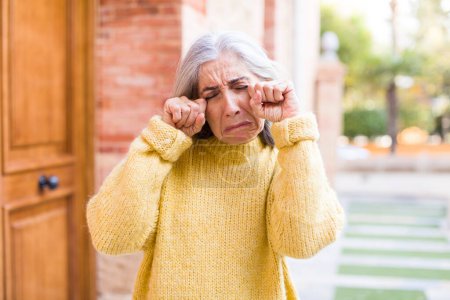 Photo for Senior retired pretty white hair woman looking desperate and frustrated, stressed, unhappy and annoyed, shouting and screaming - Royalty Free Image