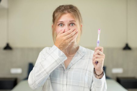 Photo for Young pretty woman covering mouth with a hand and shocked or surprised expression. toothwash concept - Royalty Free Image