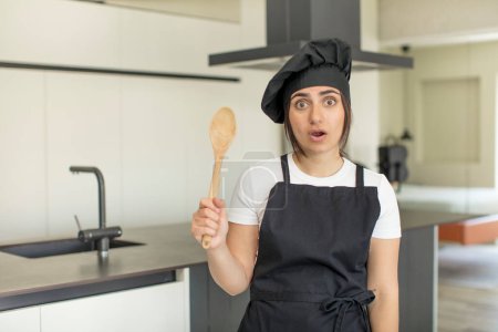 Photo for Young woman feeling extremely shocked and surprised. chef concept - Royalty Free Image