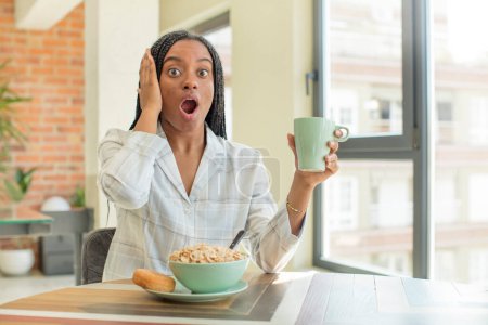 Téléchargez les photos : Afro noir femme se sentant extrêmement choqué et surpris. concept de petit déjeuner - en image libre de droit