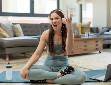 Photo for Young adult woman practicing yoga looking angry, annoyed and frustrated screaming wtf or whats wrong with you - Royalty Free Image