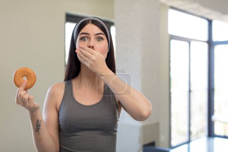 Photo for Pretty young woman covering mouth with a hand and shocked or surprised expression. donut concept - Royalty Free Image