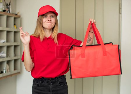 Photo for Young pretty woman crossing fingers and hoping for good luck. pizza delivery concept - Royalty Free Image