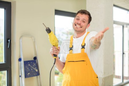 Photo for Smiling happily and offering or showing a concept handyman concept - Royalty Free Image