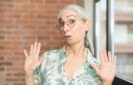 Photo for Senior pretty woman looking nervous, anxious and concerned, saying not my fault or I didnt do it - Royalty Free Image