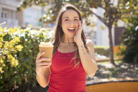 Foto de Pretty woman feeling happy and astonished at something unbelievable. take away coffee concept - Imagen libre de derechos