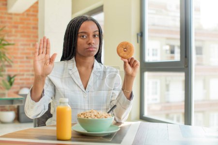 Foto de Negro afro mujer buscando grave mostrando abierta palma haciendo stop gesto. concepto de desayuno - Imagen libre de derechos