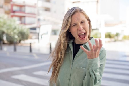 Photo for Pretty woman looking angry, annoyed and frustrated screaming wtf or whats wrong with you - Royalty Free Image