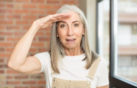 Photo for Senior pretty woman greeting the camera with a military salute in an act of honor and patriotism, showing respect - Royalty Free Image