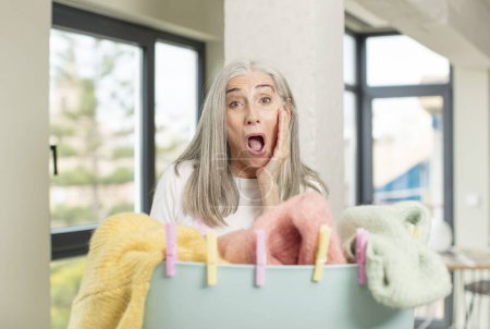 Photo for Pretty senior woman feeling happy and astonished at something unbelievable. washing clothes concept - Royalty Free Image
