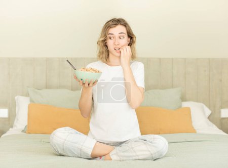 Foto de Mujer bonita sintiéndose asustada, preocupada o enojada y mirando hacia un lado. tazón de desayuno - Imagen libre de derechos