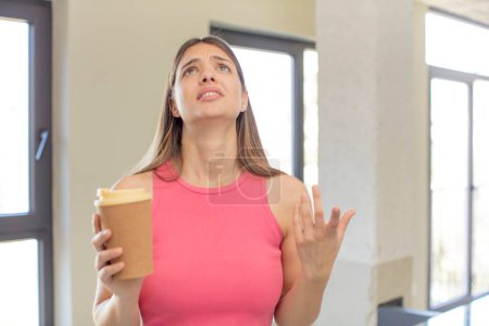 Photo for Young pretty woman screaming with hands up in the air. take away coffee concept - Royalty Free Image
