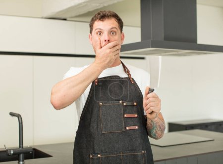 Photo for Covering mouth with a hand and shocked or surprised expression. chef at home - Royalty Free Image